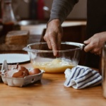 person holding clear glass bowl with brown liquid